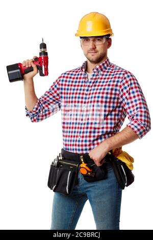 caucasian repairman worker in yellow helmet holding cordless screwdriver. handyman wearing tool belt isolated on white studio background Stock Photo