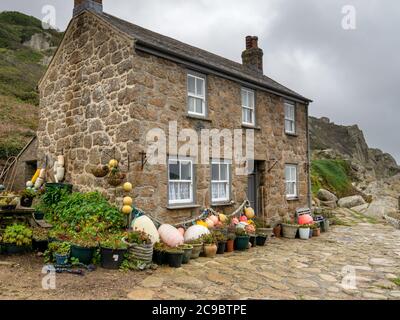 Old Cornish granite stone cottage decorated with fishing floats and potted plants, Penberth Cove, Cornwall, UK Stock Photo