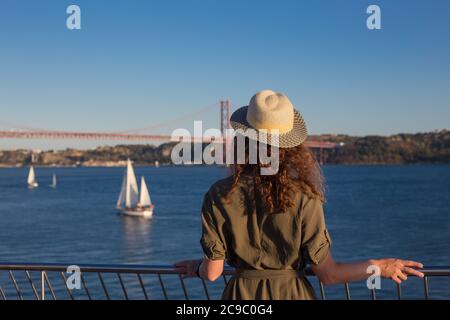 Young woman looking at bridge Ponte 25 de Abril Lisbon Stock Photo