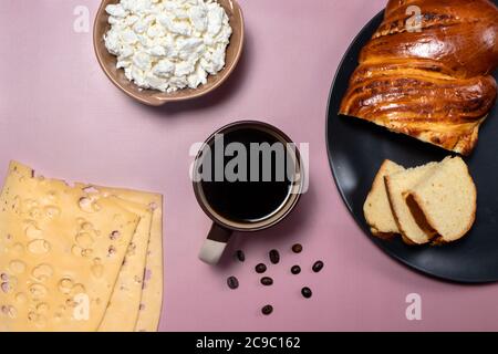 Flatlay. The idea of a delicious breakfast for the whole family. Wicker bun, cheese and aromatic black coffee. Stock Photo