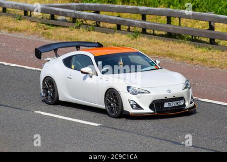 2012 white Toyota Gt86 D-4s with spoiler extended; Vehicular traffic moving vehicles, cars driving vehicle on UK roads, motors, motoring on the M6 motorway highway network. Stock Photo