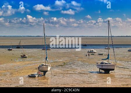 Boats on dry land at the beach with low tide in Cancale, famous oysters production town. Brittany, France Stock Photo