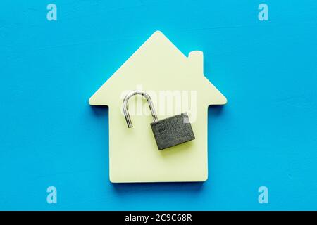 Security concept - lock and house figure - on blue desk top-down Stock Photo