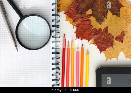 On the table is a tablet and colored pencils Stock Photo