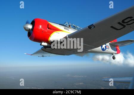 A close up air-to-air view of a USAF North American T6 Texan (Harvard) WW11 trainer, with smoke, in information with a second T6. Stock Photo