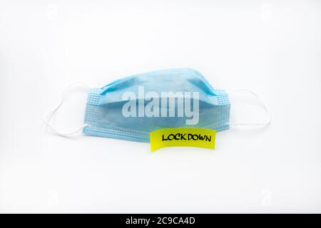 Single use medical face mask with handwritten message on post-it note Lockdown isolated over white background, coronavirus protection concept Stock Photo
