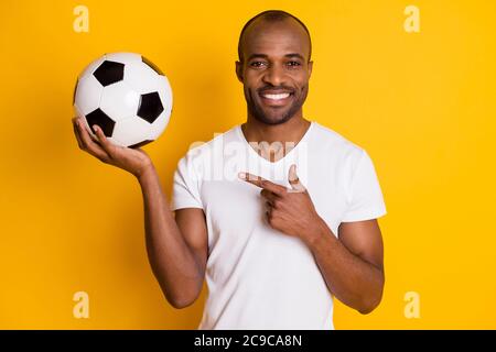 Portrait of positive cheerful afro american guy coach teach kids play football point index finger soccer ball wear stylish trendy outfit isolated Stock Photo