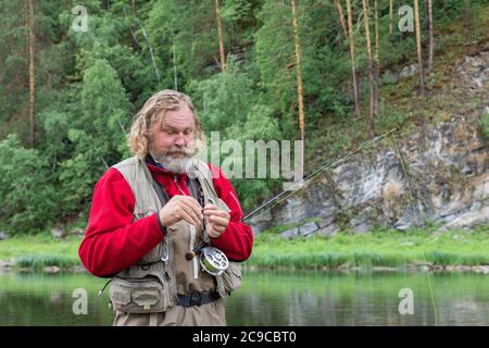 fisherman with tackle box and fishing rod Stock Photo - Alamy
