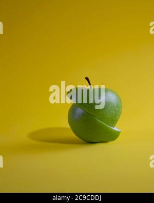 Cut green apple isolated on yellow background Stock Photo