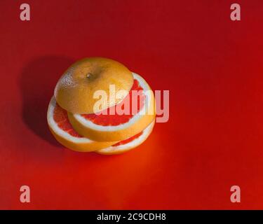 Sliced grapefruit tower isolated on red background Stock Photo