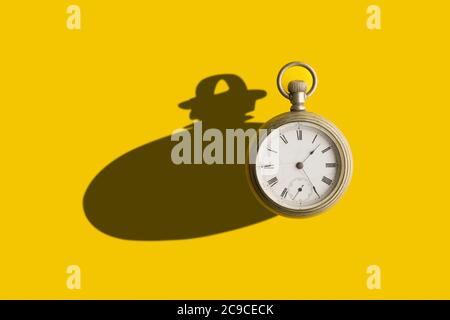 Old pocket clock with a bold shadow in a yellow background Stock Photo