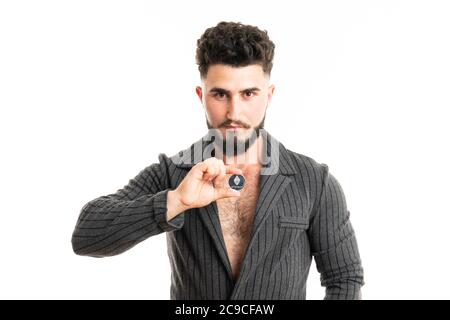 Businessman in gray suit is holding silver ethereum coin between fingers, smart contract crypto currency sign, isolated white background Stock Photo