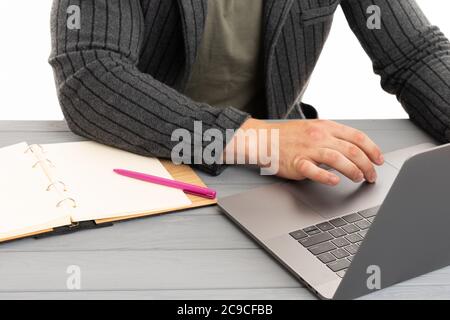 Muscular guy is working on laptop at home, sitting by the table Stock Photo