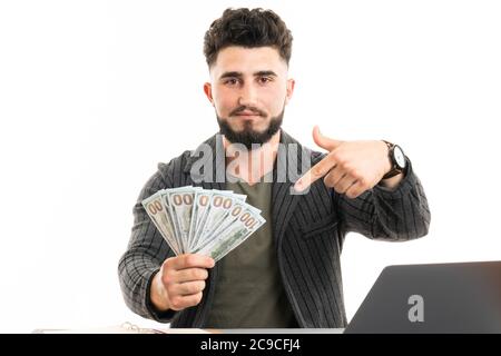 Senior man holding dollar money very happy pointing with hand and finger to the side Stock Photo