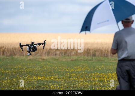 A small UAV drone quadcopter comes in to land, Winchester, UK Stock Photo