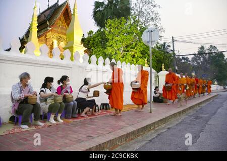 Photo taken in Luang Prabang, Laos, on March 11, 2020, shows Buddhist monks receiving morning alms, a longstanding tradition in the World Heritage-listed ancient town. (Kyodo)==Kyodo  Photo via Newscom