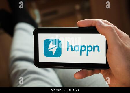 Happn application on the smartphone in mans hand. Man laying and using application for dating and meeting. Social network concept, July 2020, Prague Stock Photo