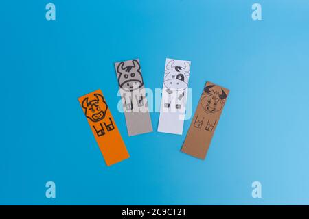 set of handmade bookmarks with bull or cow on blue background, interesting paper craft for kids Stock Photo
