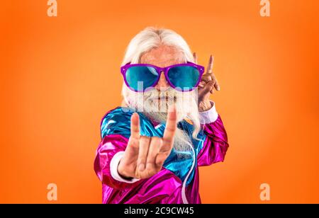 Fashionable grandfather posing with funny futuristic clothes. Senior man portraits on colored background Stock Photo