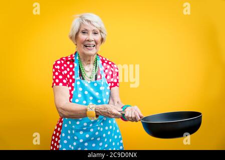 Happy grandmother posing on colored backgrounds. Woman having fun and celebrating Stock Photo