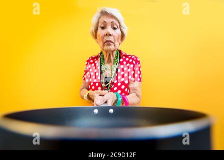 Happy grandmother posing on colored backgrounds. Woman having fun and celebrating Stock Photo