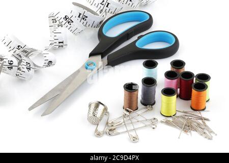 Sewing kit. Tape measure pins cotton reels on white surface Stock Photo