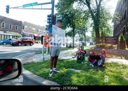 Family outside on street corner with man holding large sign begging for money. St Paul Minnesota MN USA Stock Photo