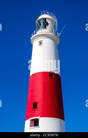 Lighthouse red and white striped tower at Portland Bill, Dorset, England, UK. Lighthouse close up photo taken in summer against a blue sky.
