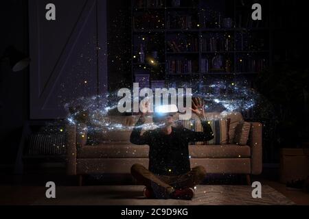 Man uses virtual reality glasses to see the galaxy space. Elements of this image furnished by NASA. Stock Photo