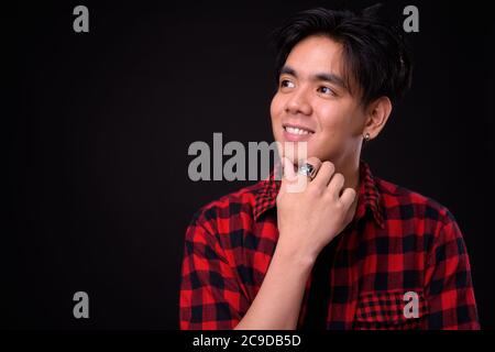 Portrait of happy young handsome Asian hipster man Stock Photo
