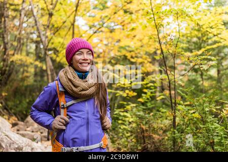 Hiking hiker girl with backpack walking on forest trail in