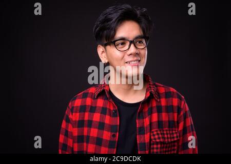 Portrait of happy young handsome Asian hipster man with eyeglasses Stock Photo