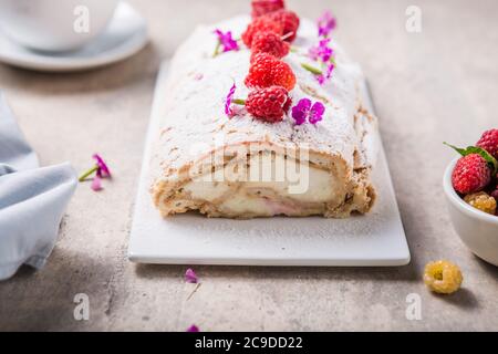 Meringue roll cake with cream and raspberries. Roulade, summer dessert, closeup. Stock Photo