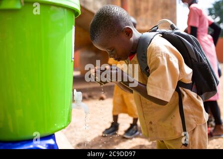 A child washes his hands at a hand washing station at his school in Conakry, Guinea, West Africa. Stock Photo