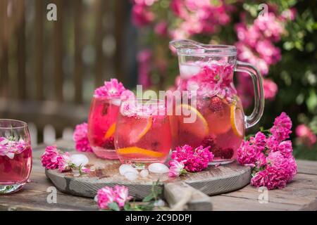 Fresh Rose lemonade or cokctail  with ice and fresh roses over natural garden Stock Photo