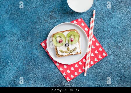 Funny breakfast toast for kids shaped as cute dog. Food art sandwich for child. Isolated. Animal faces toasts with spreads, fruits Stock Photo