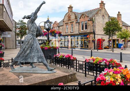 Jackie Crookston memorial statue (David Annand), Tranent, East Lothian, Scotland, UK with Keep Scotland Beautiful flowers Stock Photo