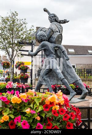 Jackie Crookston memorial statue (David Annand), Tranent, East Lothian, Scotland, UK with Keep Scotland Beautiful flowers Stock Photo