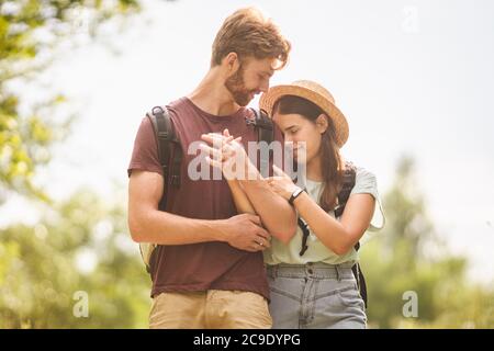 Couple Hiking Along Woodland Path. Happy loving man and woman on holiday walking together. Active lifestyle concept. Young people walking with Stock Photo