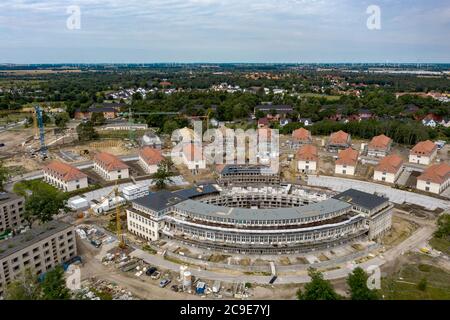 Elstal, Germany. 27th July, 2020. View of the buildings under reconstruction on the grounds of the Olympic village in Elstal in Brandenburg (shot with a drone). Since January 2019, property developer terraplan from Nuremberg has been refurbishing the listed Speisehaus der Nationen including the former boiler house, the future Haus Central. Furthermore, further new residential buildings are being constructed around these buildings. A total of around 365 apartments will be built in the first construction phase until 2022. Credit: Paul Zinken/dpa-Zentralbild/ZB/dpa/Alamy Live News Stock Photo
