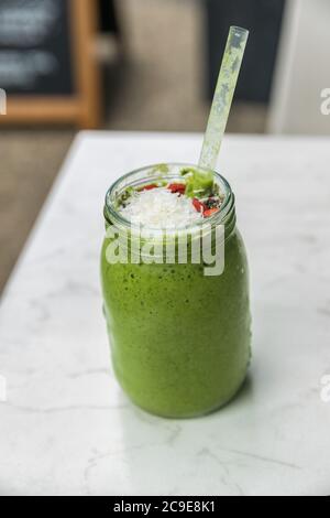 Green smoothie detox cleanse drink at cafe restaurant morning breakfast meal replacement for weight loss diet. Healthy eating lifestyle. Stock Photo