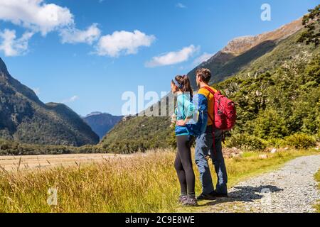 New Zealand hikers backpackers tramping on Routeburn Track, famous trail in the South Island of New Zealand. Couple looking at nature landscape Stock Photo