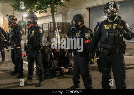Portland, USA. 30th July, 2020. Homeland Security officers arrest a protester. Five hundred protesters rallied outside the Hatfield Federal Courthouse in Portland, Oregon on the night of July 29, 2020 for the 63rd consecutive night, protesting the presence of Federal officers in the city, and continuing the Black Lives Matter protests. Federal agents deployed tear gas and less-lethal munitions at about 11 pm. © John Rudoff 2020 Credit: Sipa USA/Alamy Live News Stock Photo