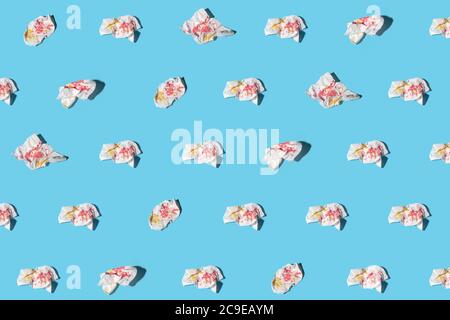 Used napkins with yellow and pink spots on blue background. Trendy isometric pattern with soft shadow. Stock Photo
