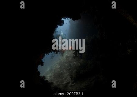 Cave with diver with torch, Hukurilla dive site, near Ambon, Maluku, Indonesia, Banda Sea, Pacific Ocean Stock Photo