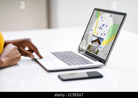 African American Woman Using Real Estate Map On Laptop Computer Stock Photo