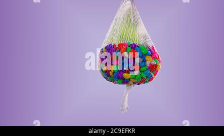 A sack of lovely colorful small pebbles with pink, blue, green, grey and white pebbles on a plain violet background Stock Photo
