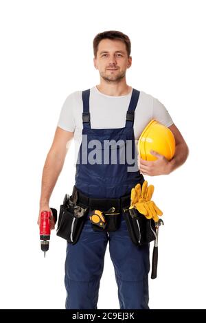 caucasian repairman worker in uniform holding yellow hard hat and cordless screwdriver. handyman wearing tool belt isolated on white studio background Stock Photo