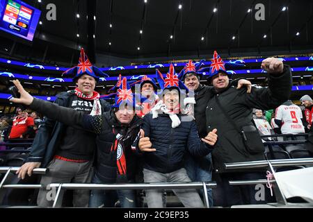LONDON, ENGLAND - FEBRUARY 19, 2020: German fans celebrate Brexit wearing Union Jack hats ahead of the first leg of the 2019/20 UEFA Champions League Round of 16 game between Tottenham Hotspur FC and RB Leipzig at Tottenham Hotspur Stadium. Stock Photo