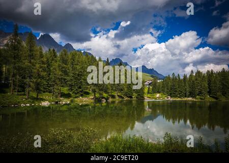 Summer view of San Pellegrino lake in Trentino. its waters reflect the magnificent Dolomites of the Val di Fassa and the Cime di Passo San Pellegrino Stock Photo